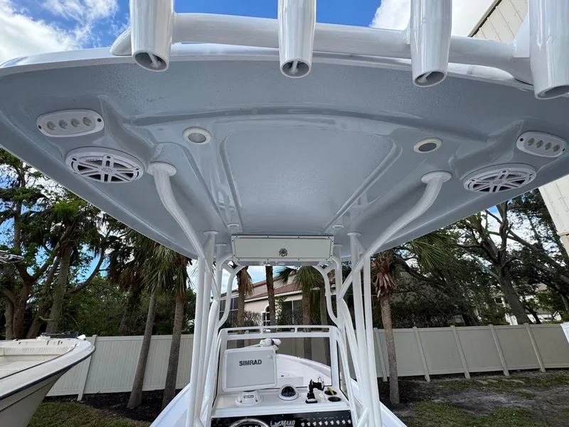 Slide: The Image of 1986 Mako 224 CC boat with T-top and rod holders, featuring Simrad electronics. - 11