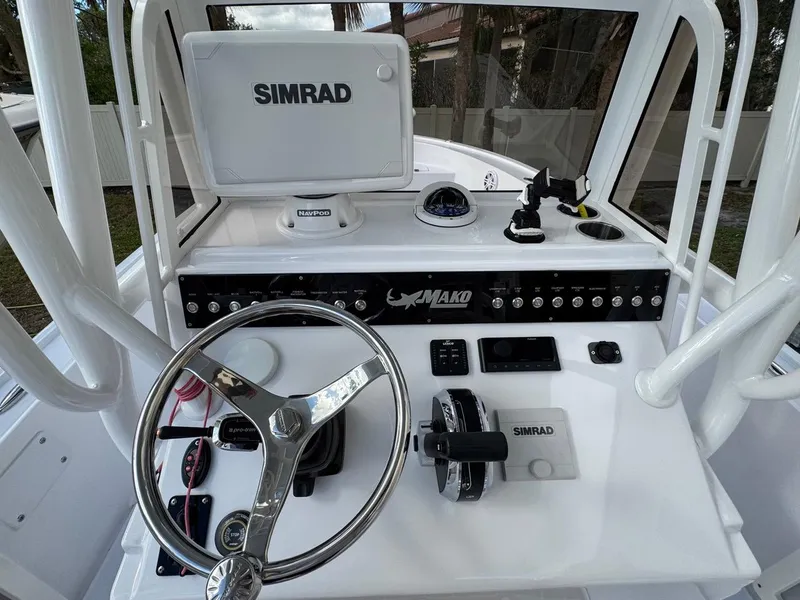 Slide: The Image of 1986 Mako 224 CC boat dashboard with Simrad navigation system and steering wheel. - 12
