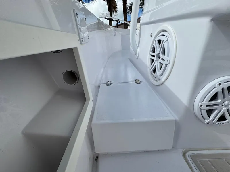 Slide: The Image of 1986 Mako 224 CC boat interior with white speakers and storage compartments. - 15