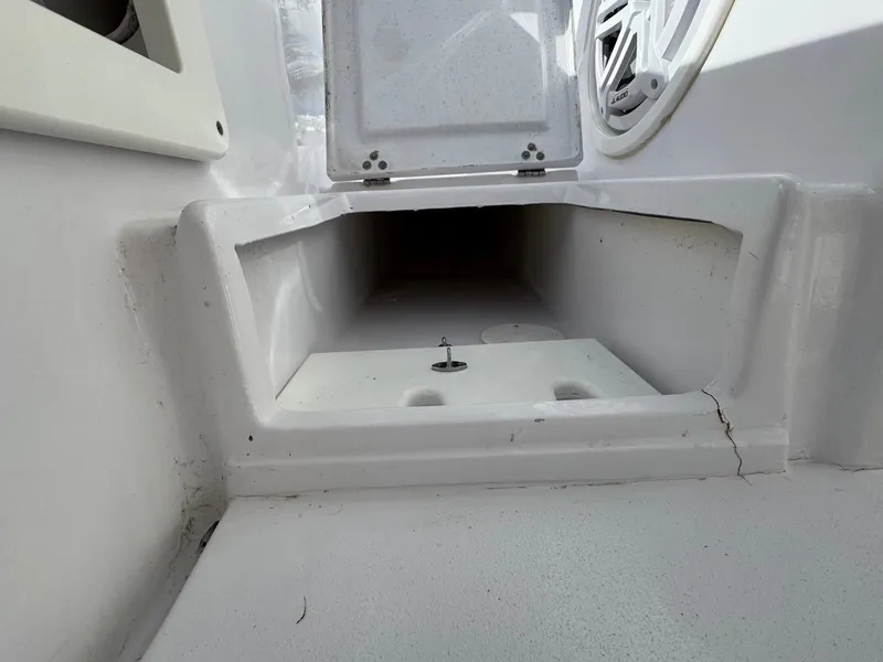 Slide: The Image of 1986 Mako 224 CC boat compartment with open hatch and visible speaker. - 16