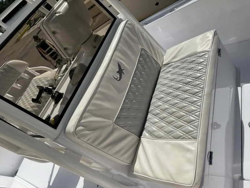 Slide: The Image of 1986 Mako 224 CC boat interior with diamond-stitched white seating. - 18