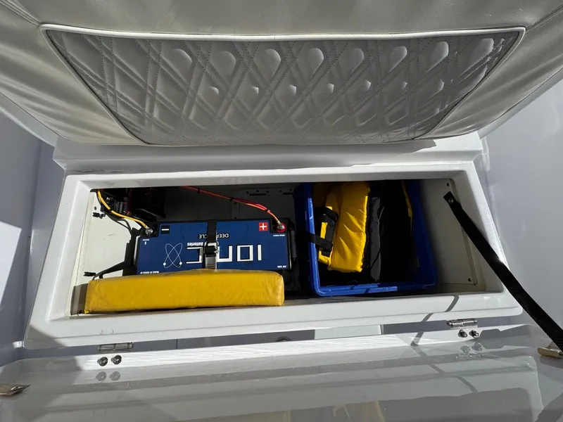 Slide: The Image of 1986 Mako 224 CC boat storage compartment with battery and safety gear. - 19