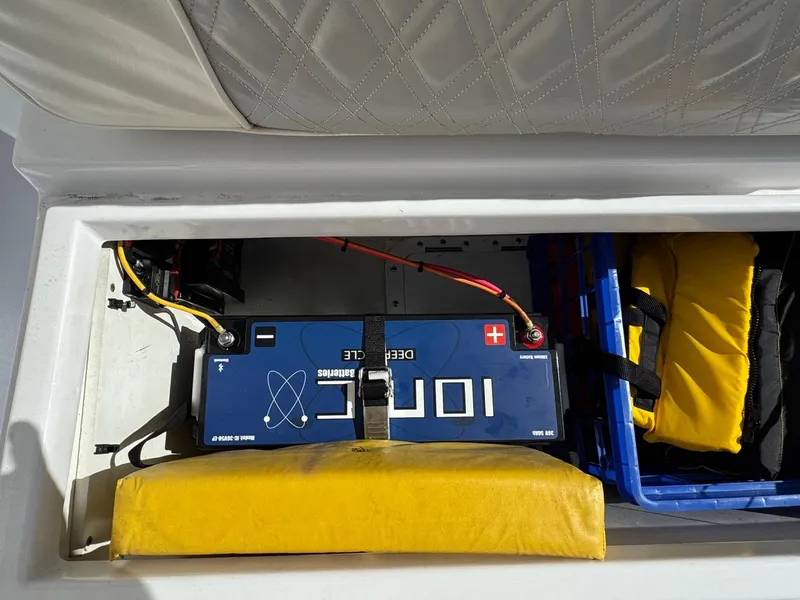 Slide: The Image of 1986 Mako 224 CC boat battery compartment with safety equipment and storage. - 20