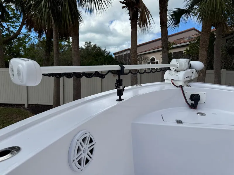 Slide: The Image of 1986 Mako 224 CC boat with mounted trolling motor and speaker, surrounded by palm trees. - 23