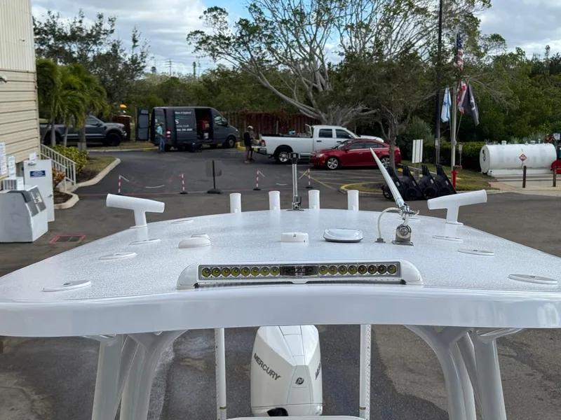 Slide: The Image of 1986 Mako 224 CC boat with Mercury engine, parked outdoors. - 25