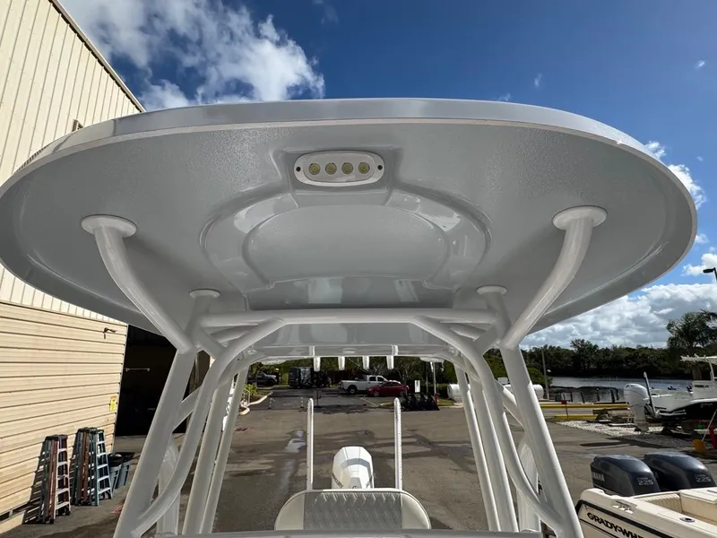 Slide: The Image of 1986 Mako 224 CC boat with T-top and LED light, docked under blue sky. - 26