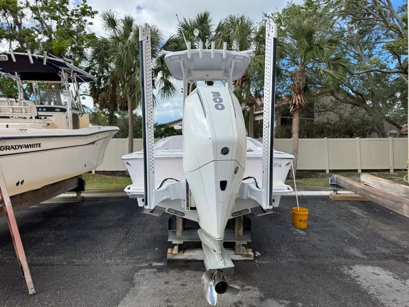 Slide: The Image of 1986 Mako 224 CC boat with outboard motor, parked on a lot with palm trees. - 3