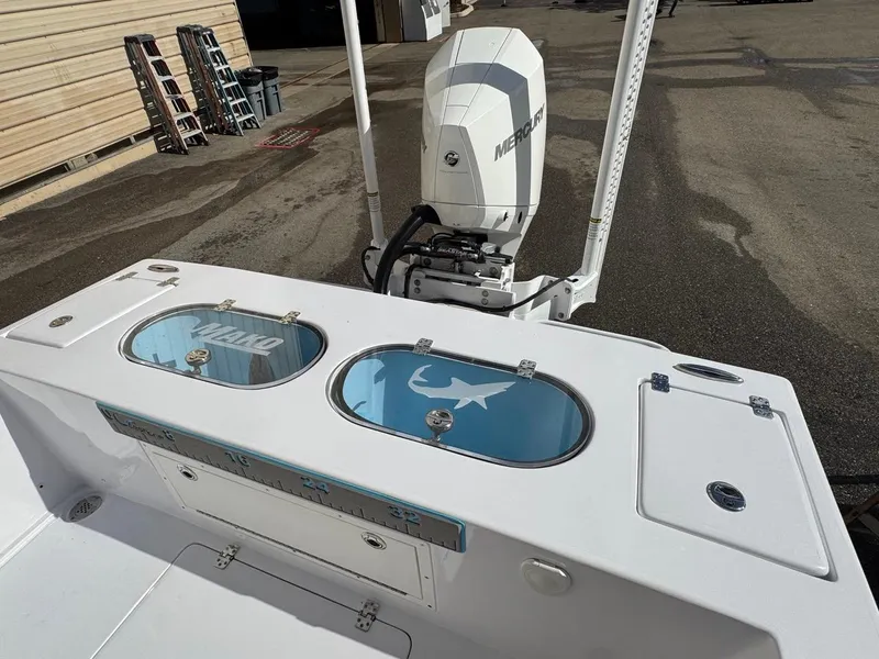 Slide: The Image of 1986 Mako 224 CC boat with Mercury engine, featuring dual livewells and storage compartments. - 6