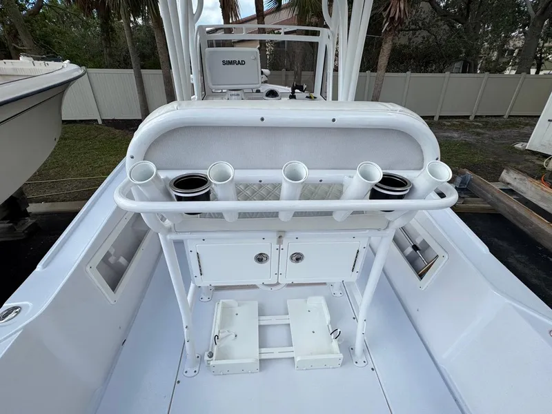 Slide: The Image of 1986 Mako 224 CC boat interior with rod holders and storage compartments. - 7