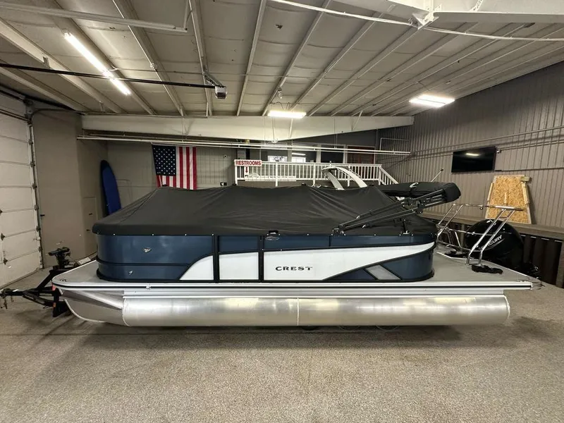 Slide: The Image of 2025 Crest Classic 220 SLC 3 Toon pontoon boat in indoor storage with cover. - 13