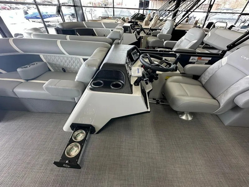 Slide: The Image of 2025 Crest Classic 220 SLC 3 Toon interior with modern seating and steering console. - 7