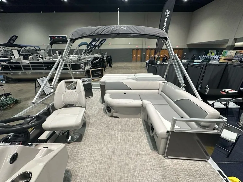 Slide: The Image of 2025 Avalon 2185 Venture CR pontoon boat with spacious seating at a boat show. - 5