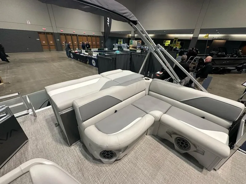 Slide: The Image of 2025 Avalon 2185 Venture CR pontoon boat interior with plush seating at a boat show. - 9