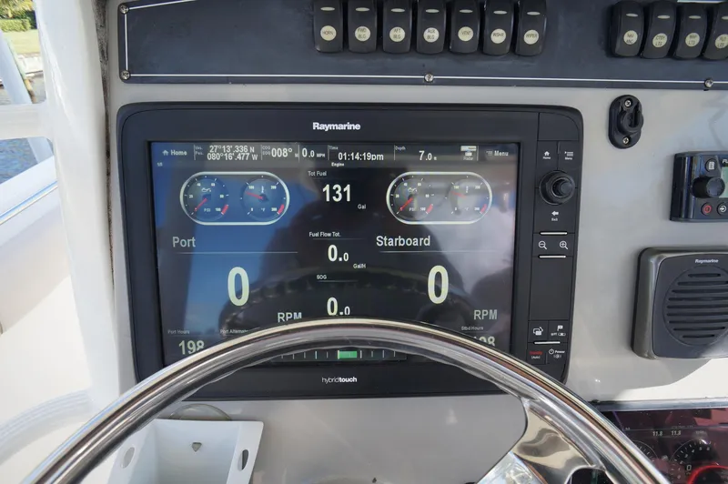 Slide: The Image of Boston Whaler 330 Outrage 2017 dashboard with Raymarine display and steering wheel. - 16