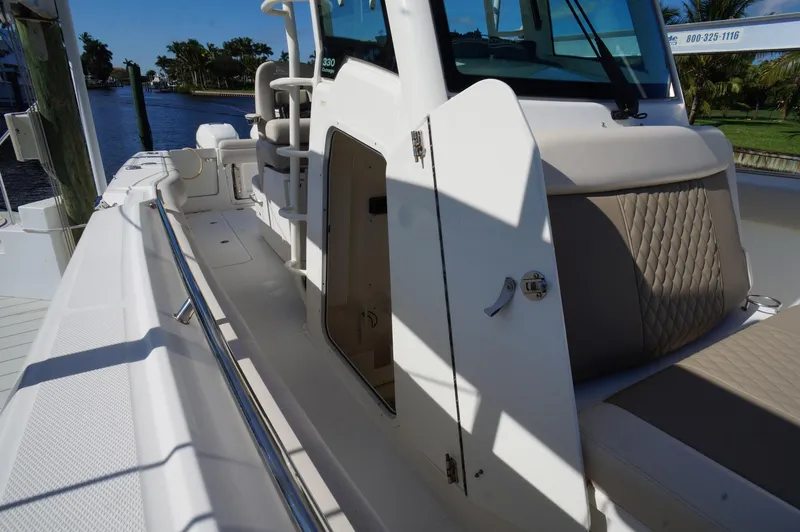 Slide: The Image of 2017 Boston Whaler 330 Outrage boat deck and seating area, docked by the water. - 21