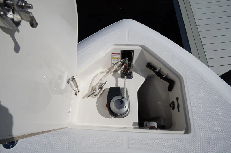 Slide: The Image of 2017 Boston Whaler 330 Outrage anchor locker with winch and storage compartment. - 24