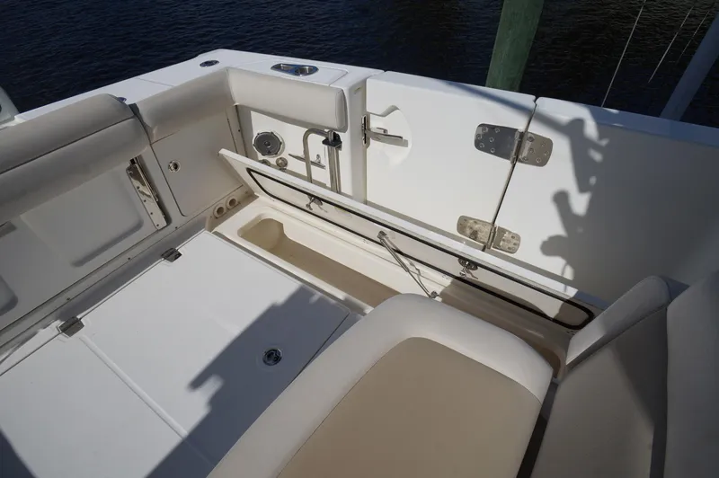 Slide: The Image of 2017 Boston Whaler 330 Outrage boat interior, featuring seating and storage compartments. - 26