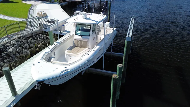 Slide: The Image of 2017 Boston Whaler 330 Outrage boat docked on lift by waterfront. - 28