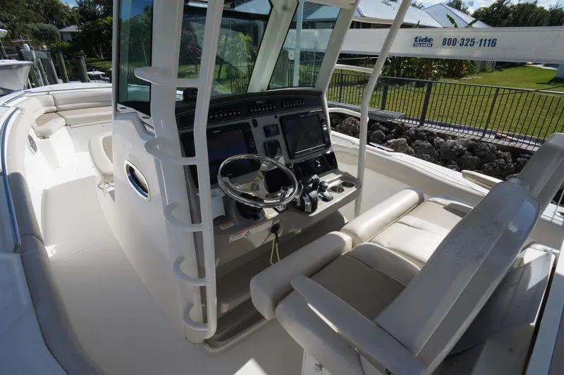 Slide: The Image of 2017 Boston Whaler 330 Outrage boat cockpit with steering wheel and navigation screens. - 4