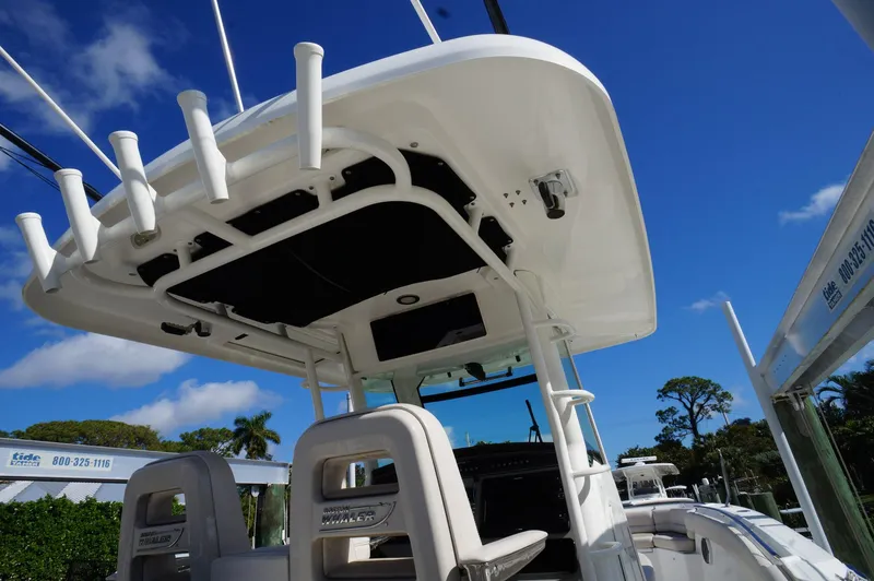 Slide: The Image of 2017 Boston Whaler 330 Outrage boat, view of helm and seating under clear blue sky. - 7