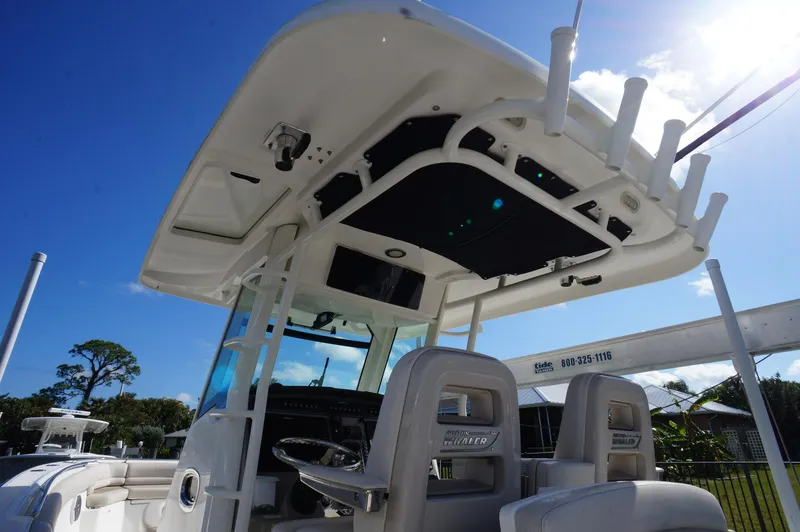 Slide: The Image of 2017 Boston Whaler 330 Outrage boat interior with helm and seating under blue sky. - 8