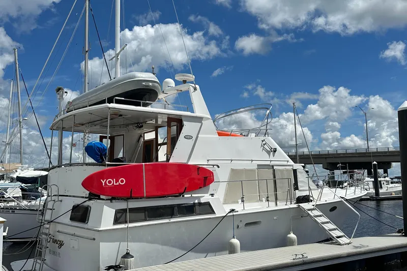 Slide: The Image of 1988 Marine Trader Trawler docked under a blue sky with clouds. - 1