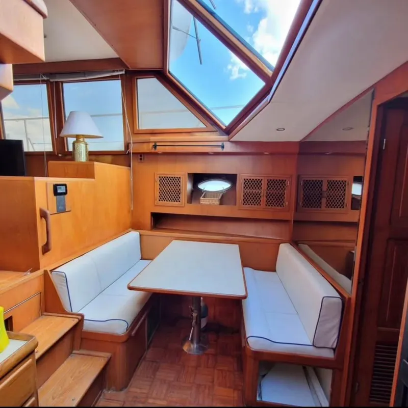 Slide: The Image of 1988 Marine Trader Trawler interior with skylight, wooden finishes, and cozy seating area. - 10