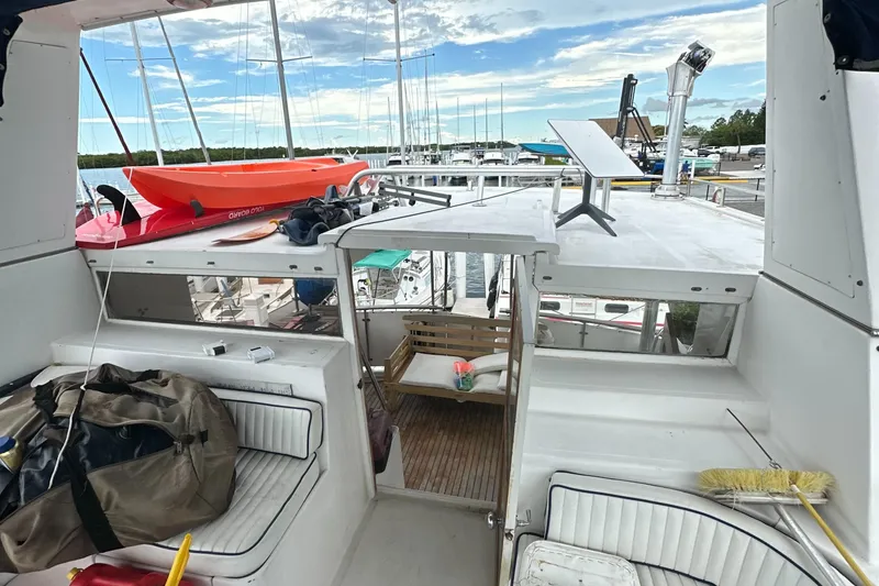 Slide: The Image of 1988 Marine Trader Trawler deck with seating, kayak, and marina view. - 2