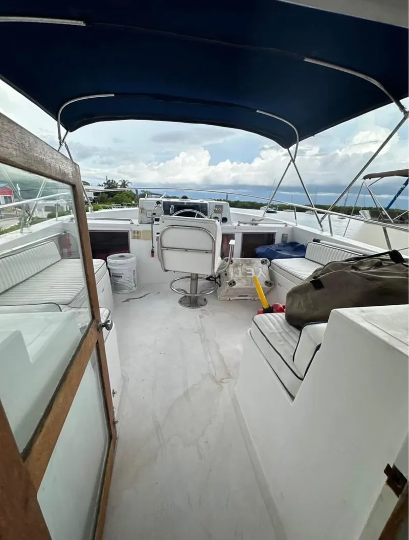 Slide: The Image of 1988 Marine Trader Trawler interior with seating, helm, and blue canopy. - 3
