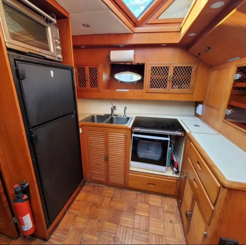 Slide: The Image of 1988 Marine Trader Trawler kitchen with wood cabinetry, stove, and refrigerator. - 9