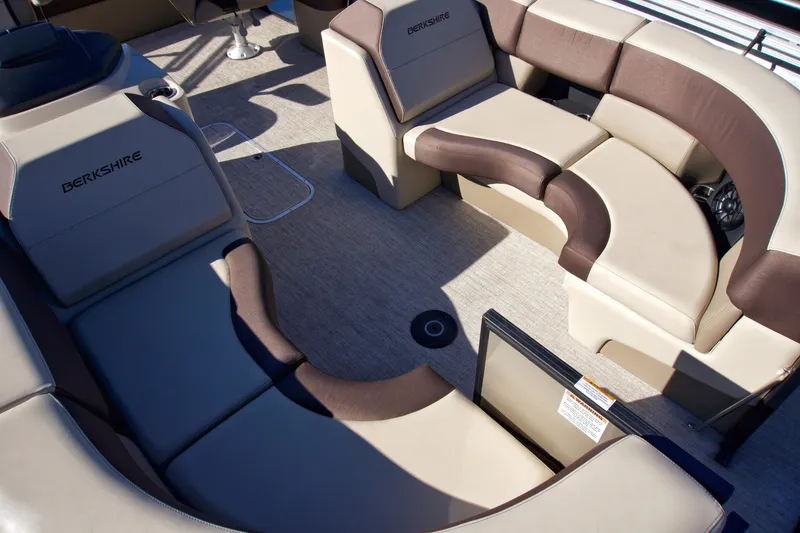 Slide: The Image of 2024 Berkshire 23ULSTS3-93 boat interior with beige and brown seating arrangement. - 3