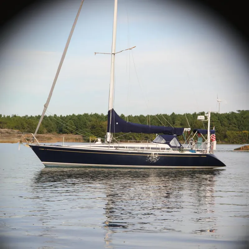 The Image of Nautor Swan 44MKII 2001 sailboat on calm water, forested shoreline in background. - 0