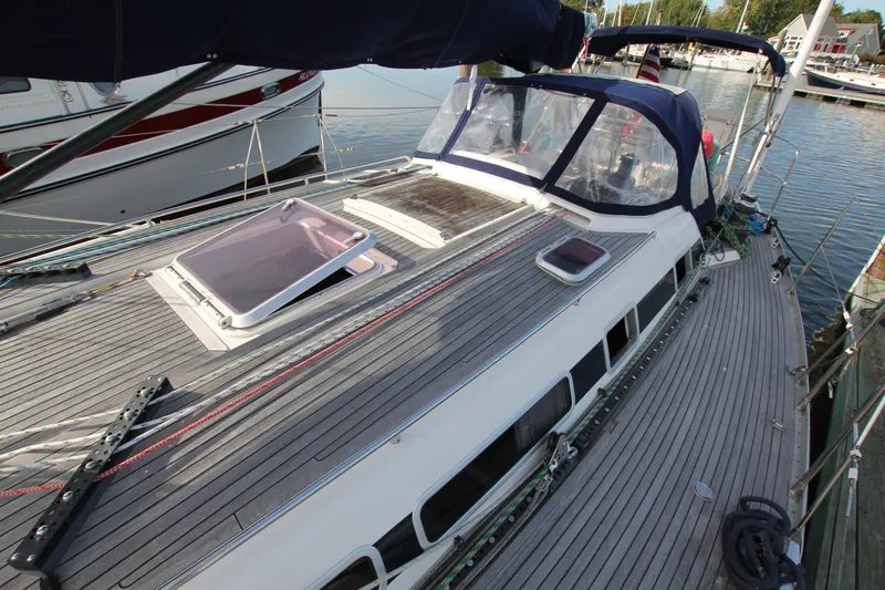 Slide: The Image of Nautor Swan 44MKII sailboat deck, 2001 model, docked at marina with visible hatches and canopy. - 10