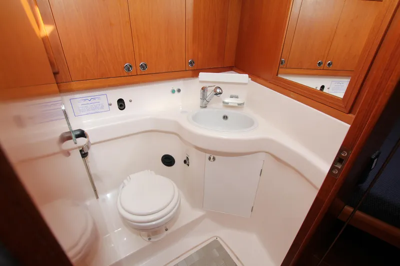 Slide: The Image of Bathroom interior of 2001 Nautor Swan 44MKII yacht with wooden cabinets and white fixtures. - 28