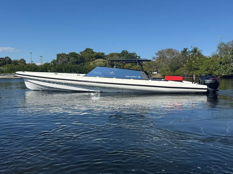 Slide: The Image of 2024 Goldfish 46 Open boat on calm water, surrounded by lush greenery. - 6