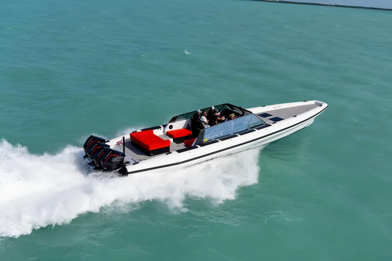 Slide: The Image of 2024 Goldfish 46 Open speedboat cruising on turquoise water. - 8