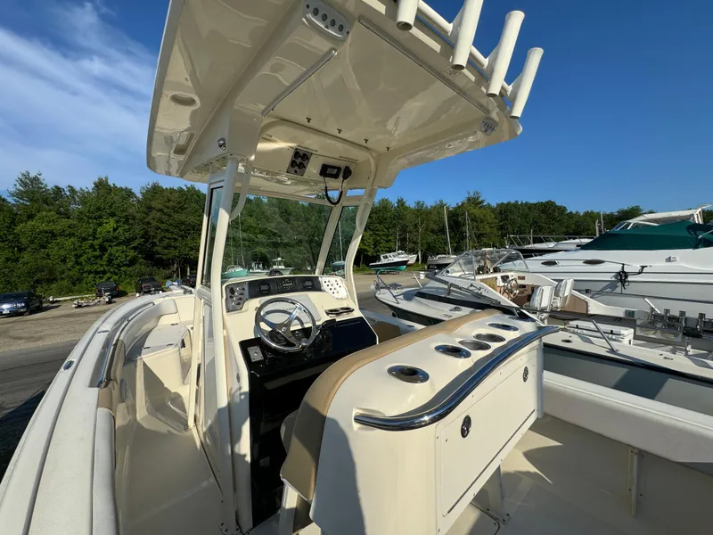 Slide: The Image of 2014 Scout 245 XSF boat interior with steering console and rod holders. - 18