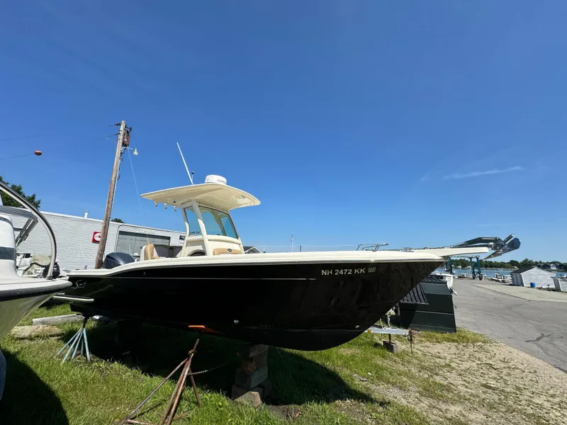 Slide: The Image of 2014 Scout 245 XSF boat on display under clear blue sky. - 2