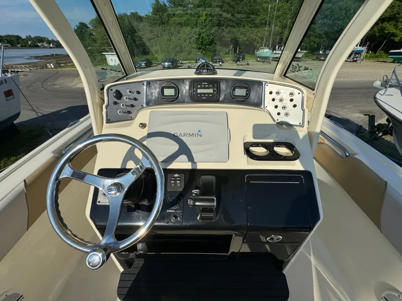 Slide: The Image of 2014 Scout 245 XSF boat dashboard with steering wheel and Garmin navigation system. - 24