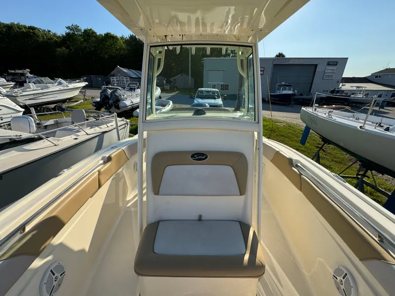 Slide: The Image of 2014 Scout 245 XSF boat interior with seating, parked in a marina. - 32
