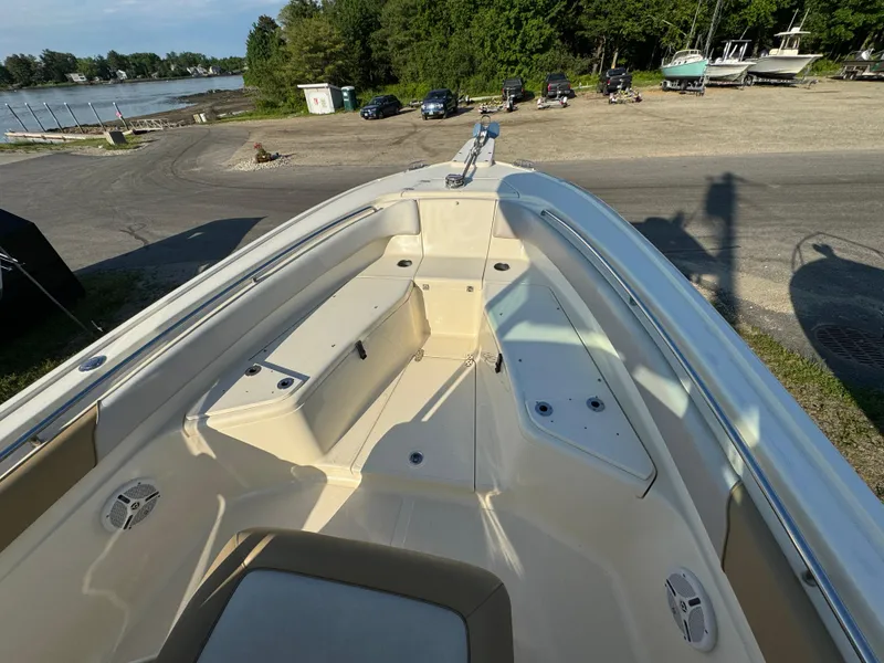 Slide: The Image of 2014 Scout 245 XSF boat interior with seating, docked near a scenic waterfront. - 35
