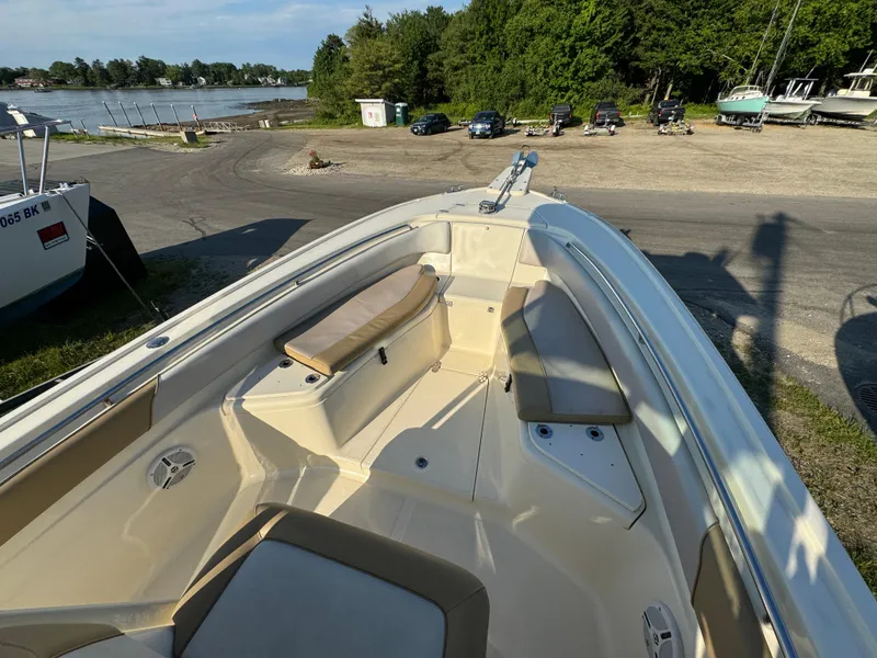 Slide: The Image of 2014 Scout 245 XSF boat with spacious seating, docked near a scenic waterfront. - 36