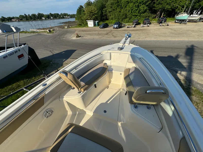 Slide: The Image of 2014 Scout 245 XSF boat interior with seating, docked near a scenic waterfront. - 37