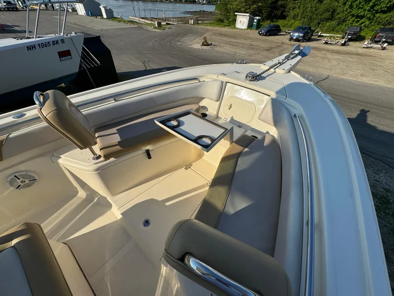 Slide: The Image of 2014 Scout 245 XSF boat interior with seating and table, docked near water. - 38