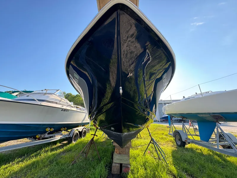 Slide: The Image of 2014 Scout 245 XSF boat on stands, surrounded by other boats, under clear blue sky. - 4