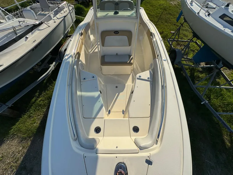 Slide: The Image of 2014 Scout 245 XSF boat, top view, beige interior, docked on grass. - 47