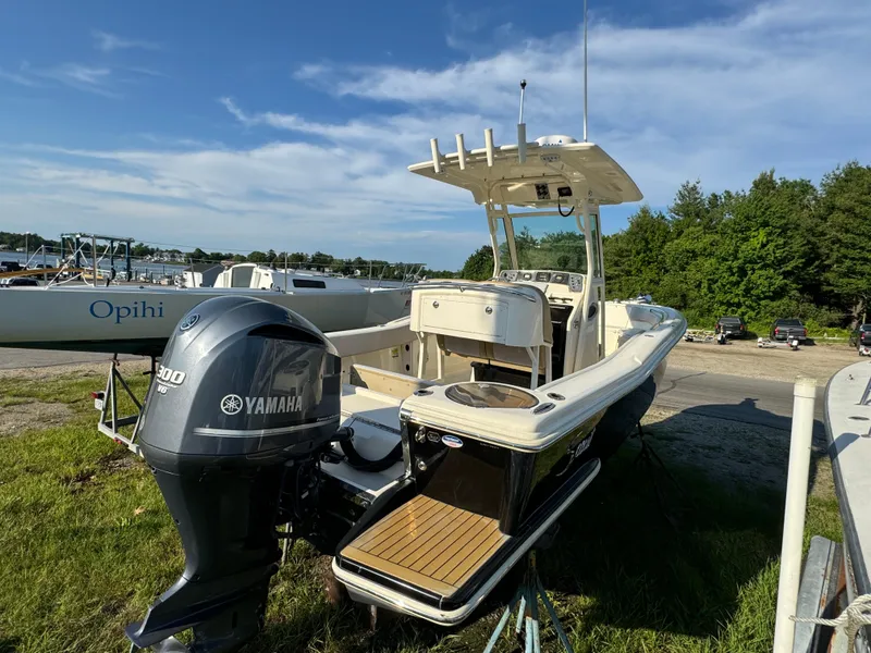 Slide: The Image of 2014 Scout 245 XSF boat with Yamaha engine, parked outdoors under blue sky. - 9
