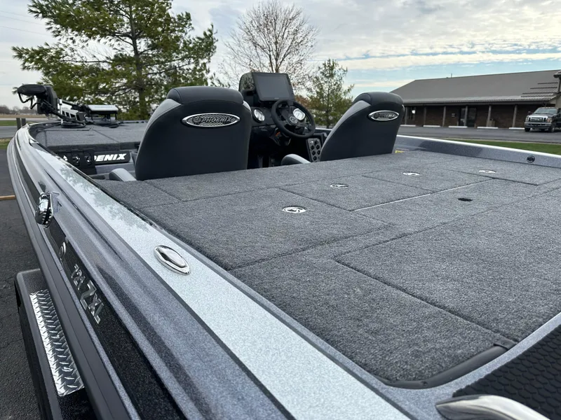 Slide: The Image of 2025 Phoenix 721 ZXL boat with spacious deck and dual seats, parked outdoors. - 9
