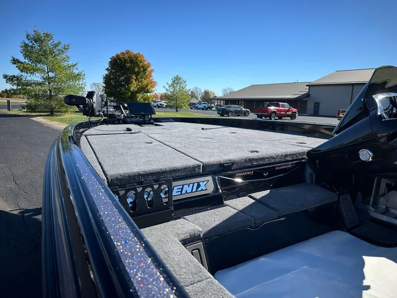 Slide: The Image of 2025 Phoenix 21 XE boat deck with storage compartments, parked outdoors. - 10