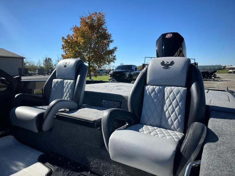 Slide: The Image of 2025 Phoenix 21 XE boat seats with diamond stitching, parked outdoors under clear blue sky. - 11